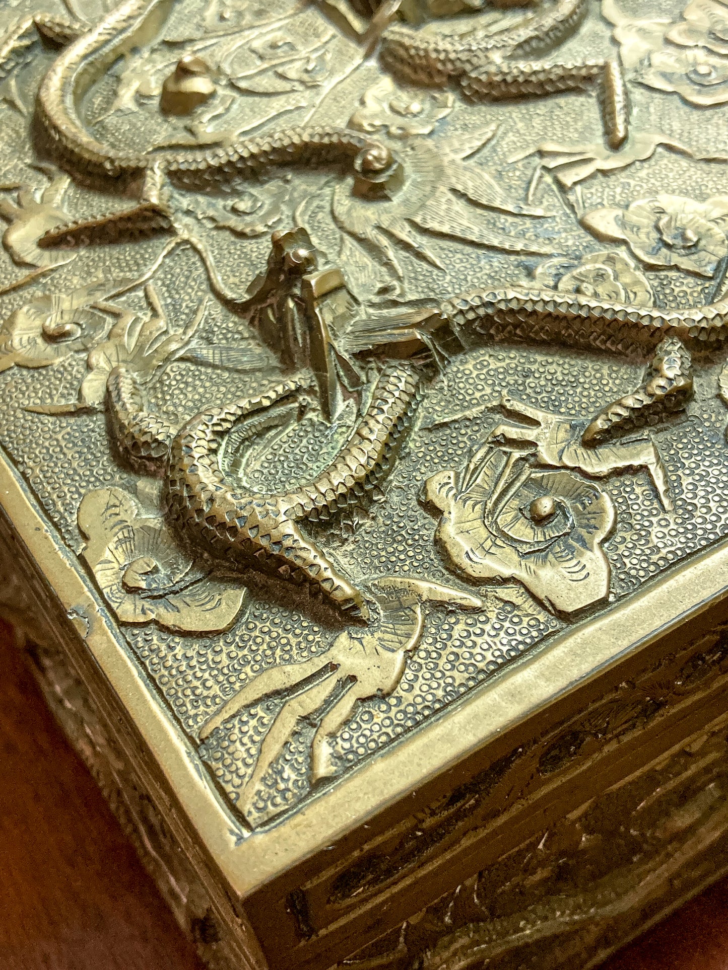 Close-up of a brass box with intricate designs Antique Hand Engraved Sculptural Brass Dragon Wood Lined Cigar Box
