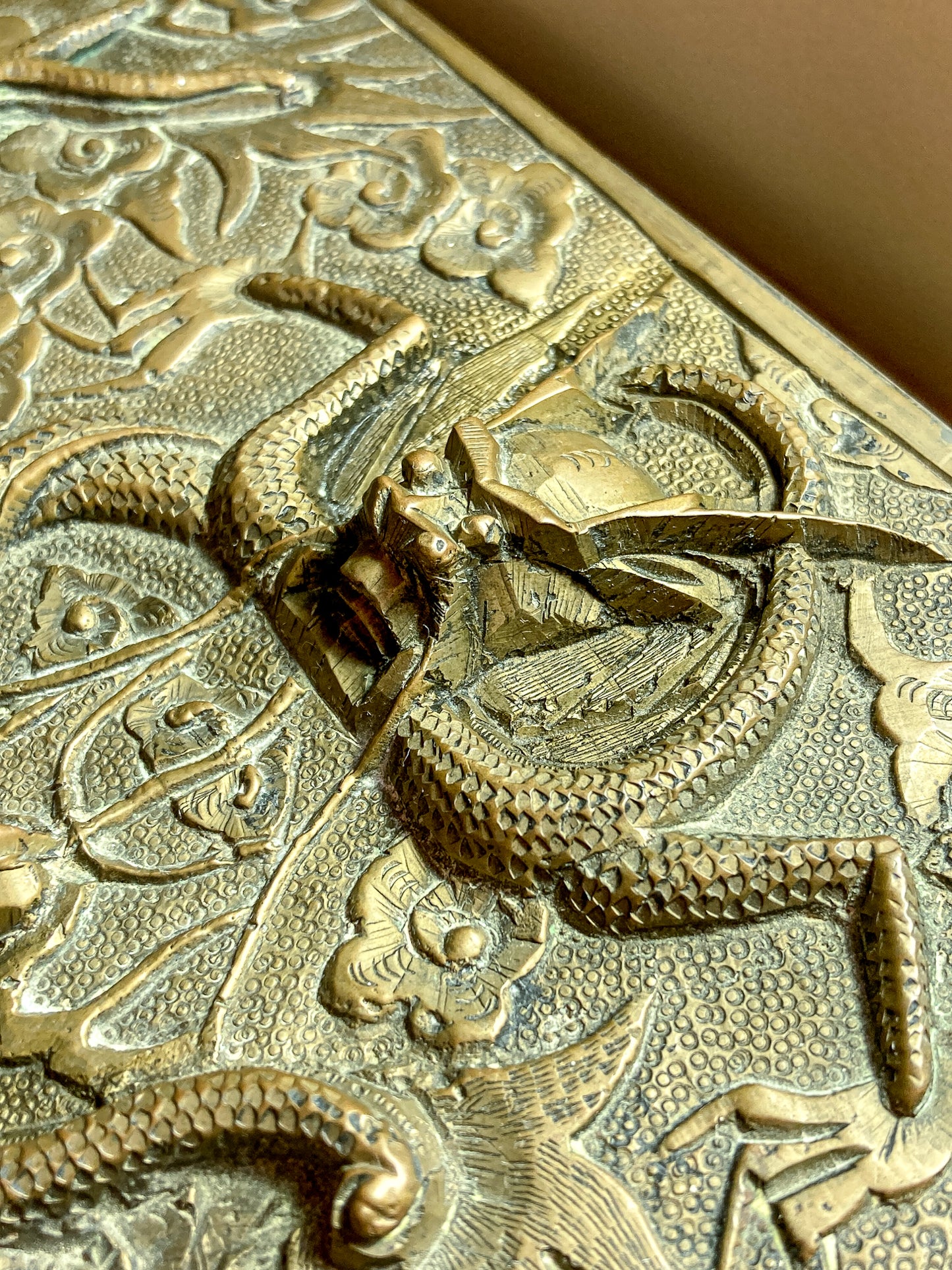 Close-up of a detailed brass dragon design on a textured surface Antique Hand Engraved Sculptural Brass Dragon Wood Lined Cigar Box