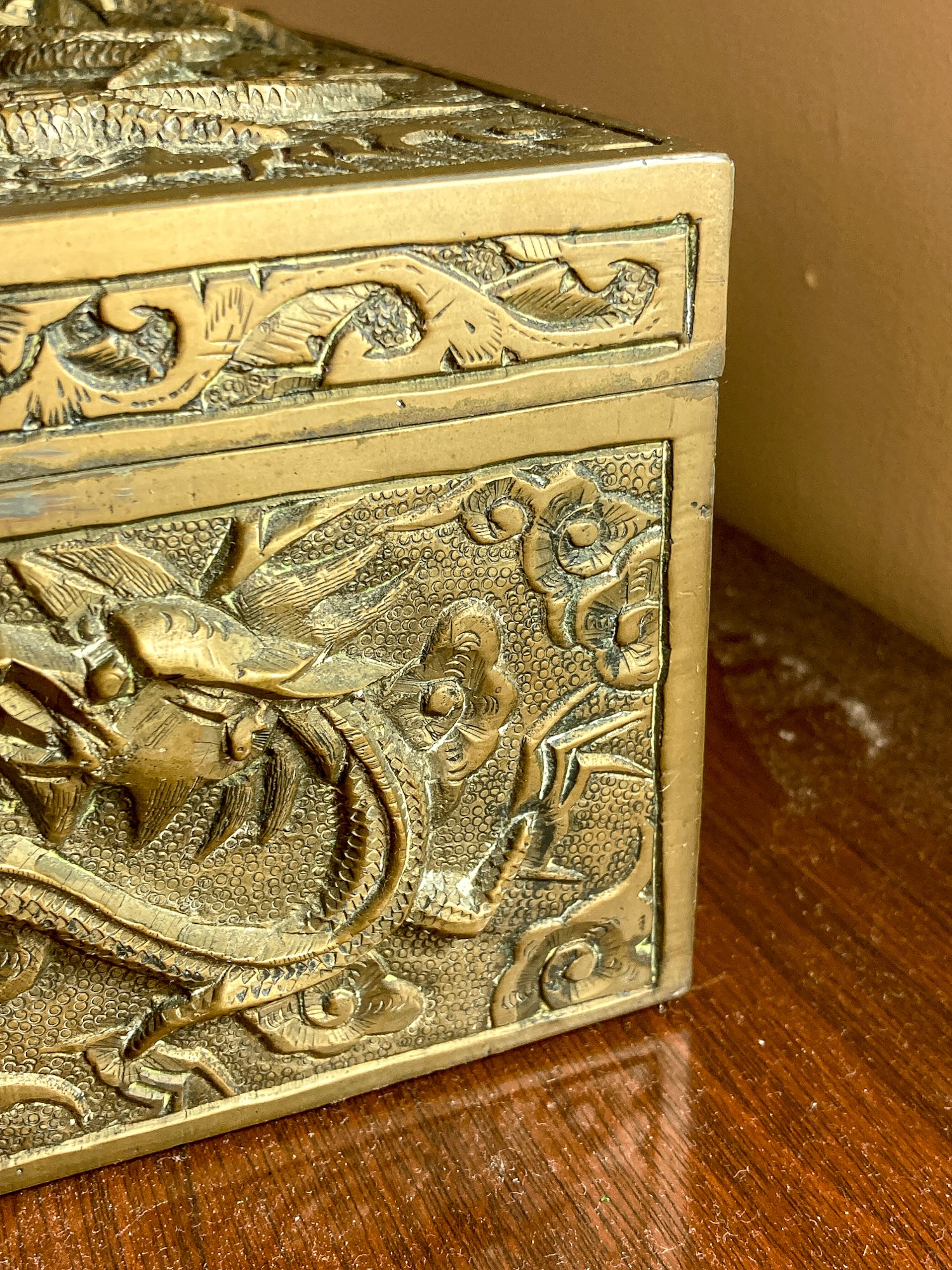 Decorative brass box with intricate carvings on a wooden surface Antique Hand Engraved Sculptural Brass Dragon Wood Lined Cigar Box