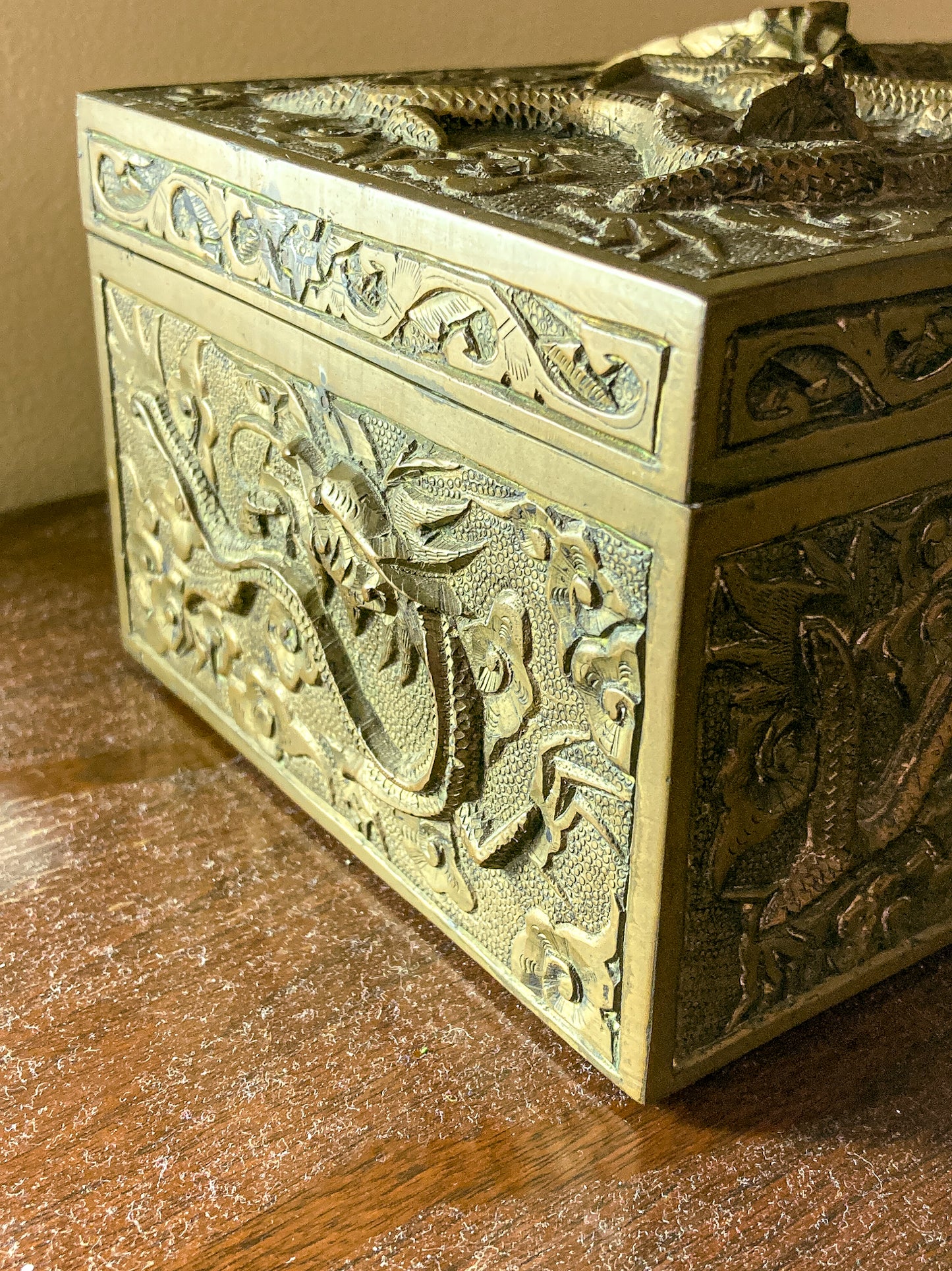 Decorative brass box with intricate carvings on a wooden surface Antique Hand Engraved Sculptural Brass Dragon Wood Lined Cigar Box