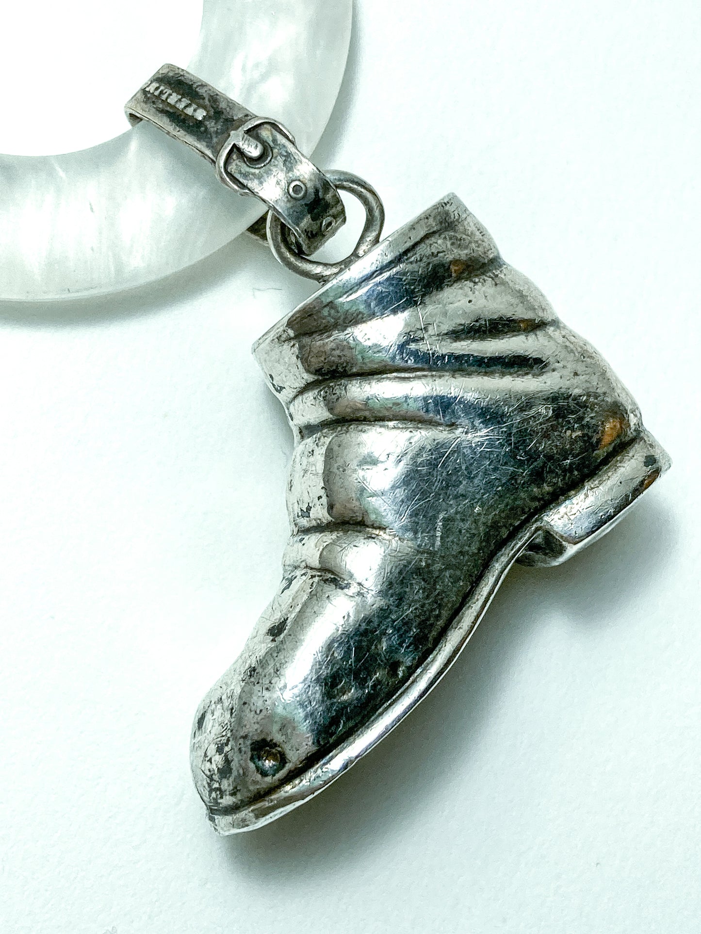 Antique Victorian Sterling Silver Baby Shoe Mother of Pearl Rattle on white background close up