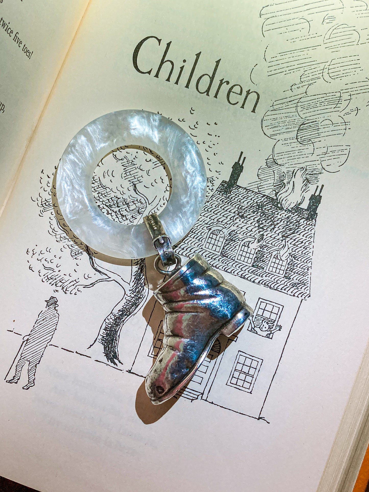 Antique Victorian Sterling Silver Baby Shoe Mother of Pearl Rattle on illustrated page background that says children