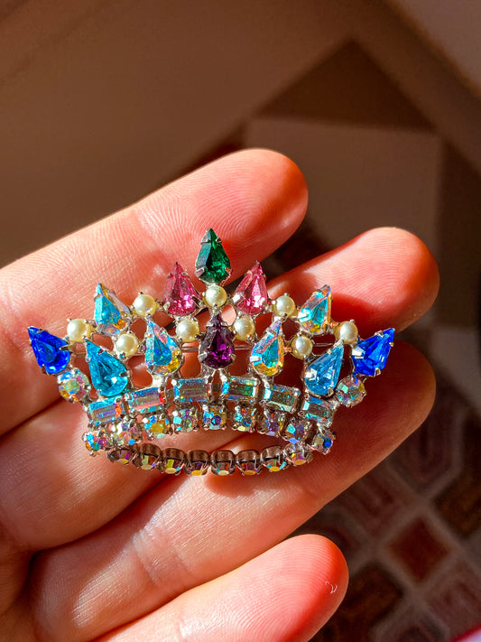 Multicolored jeweled crown brooch held in a hand with a blurred background Vintage B. David Colorful Iridescent Rhinestone Pearl Crown Brooch Pin Jewelry