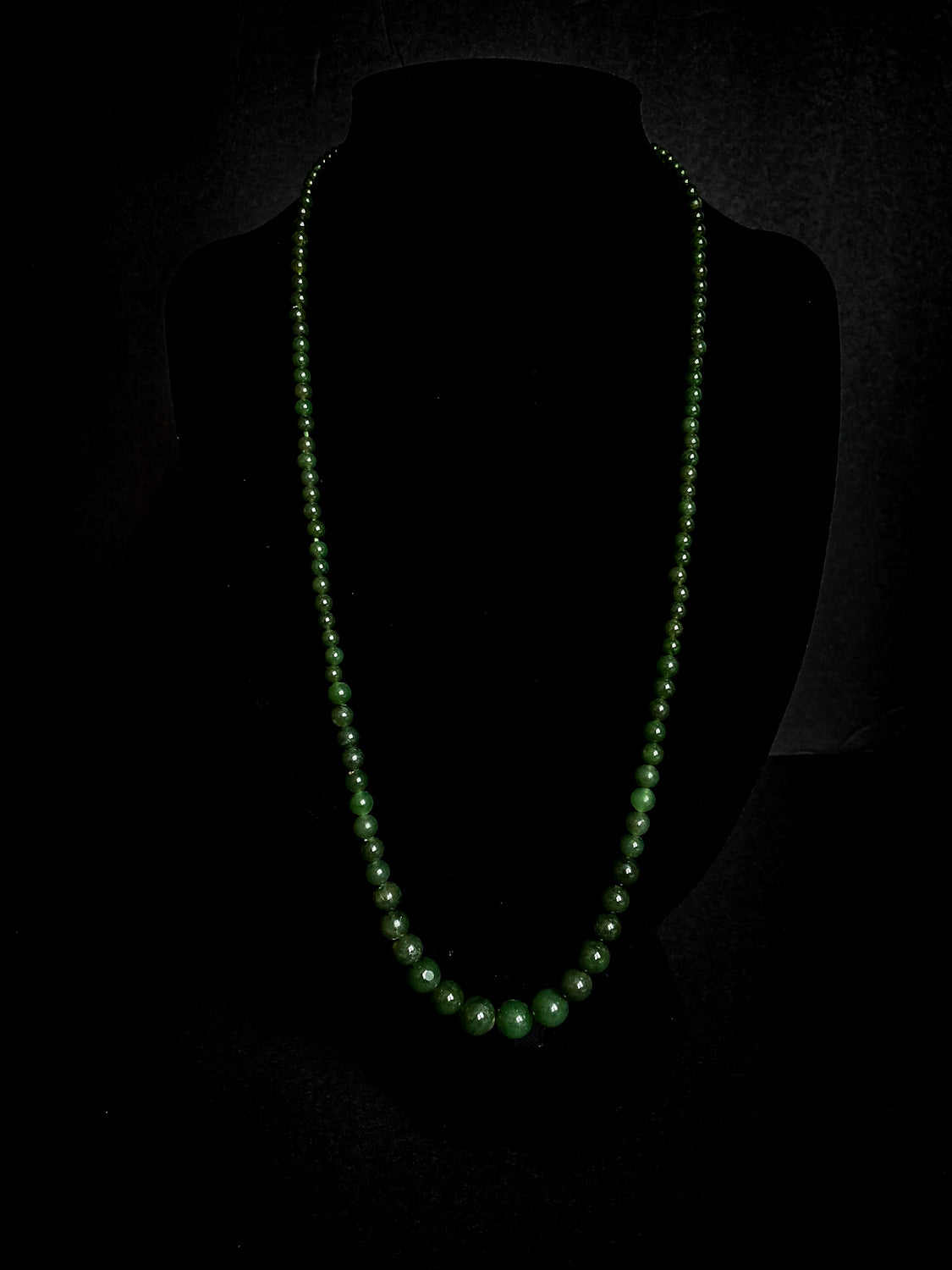 Vintage Graduated Green Nephrite Stone Bead Elongated Necklace on black velvet form