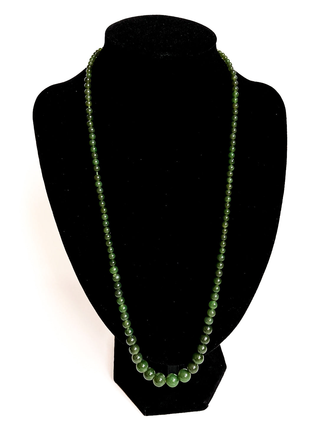 Vintage Graduated Green Nephrite Stone Bead Elongated Necklace on black velvet form white background