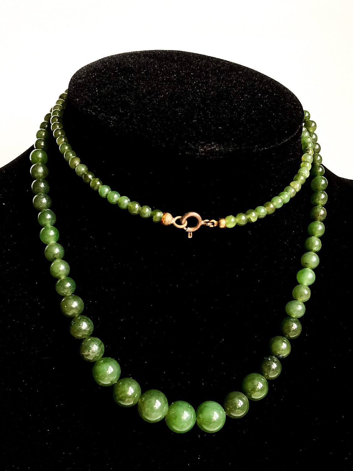 Vintage Graduated Green Nephrite Stone Bead Elongated Necklace doubled on black velvet form