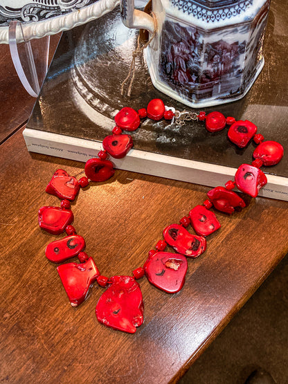Bold LUC Lucas Lameth Red Coral Stone Graduated Bead Sterling Silver Necklace on wooden table and black and white book.