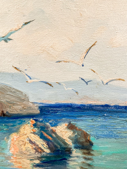 Impressionistic painting of seagulls flying over a blue ocean with rocky shoreline and pale sky. Vintage 1960s Greece Village Seaside Boat Dock Landscape Signed Framed Oil Painting