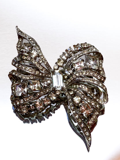 Vintage Coro Sterling Silver Clear Glass Rhinestone Asymmetric Bow Brooch Pin on white background