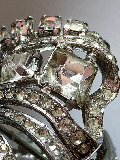 Vintage Coro Sterling Silver Clear Glass Rhinestone Asymmetric Bow Brooch Pin on mirrored white background close up chipped rhinestone