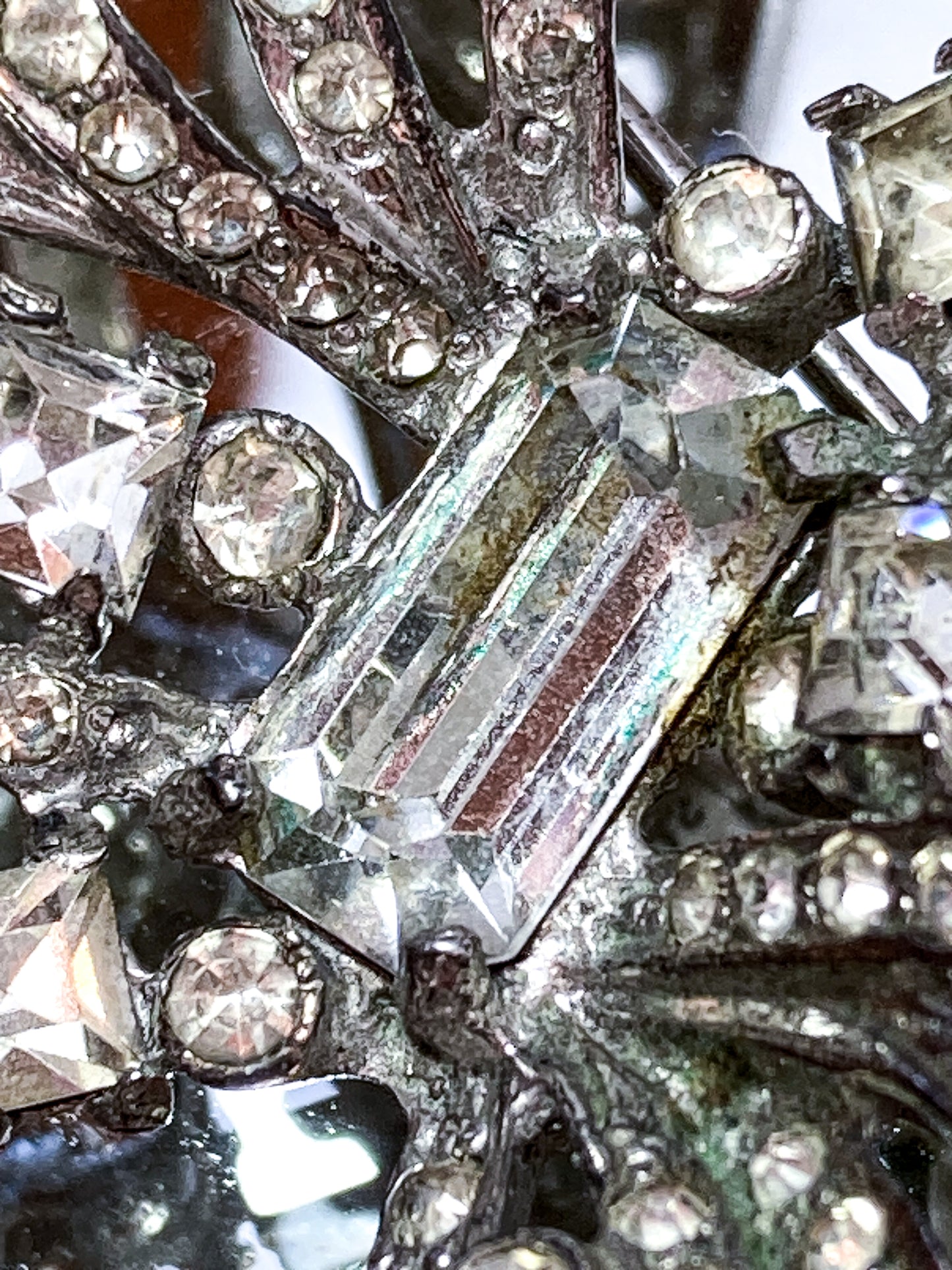 Vintage Coro Sterling Silver Clear Glass Rhinestone Asymmetric Bow Brooch Pin on mirrored white background close up