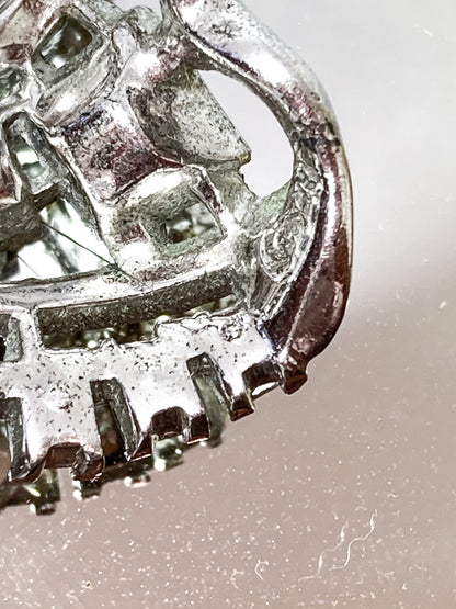 Vintage Coro Sterling Silver Clear Glass Rhinestone Asymmetric Bow Brooch Pin on mirrored white background close up coro logo