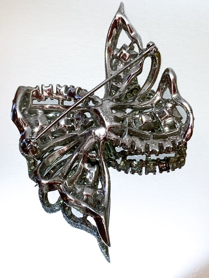 Vintage Coro Sterling Silver Clear Glass Rhinestone Asymmetric Bow Brooch Pin on mirrored white background close up back