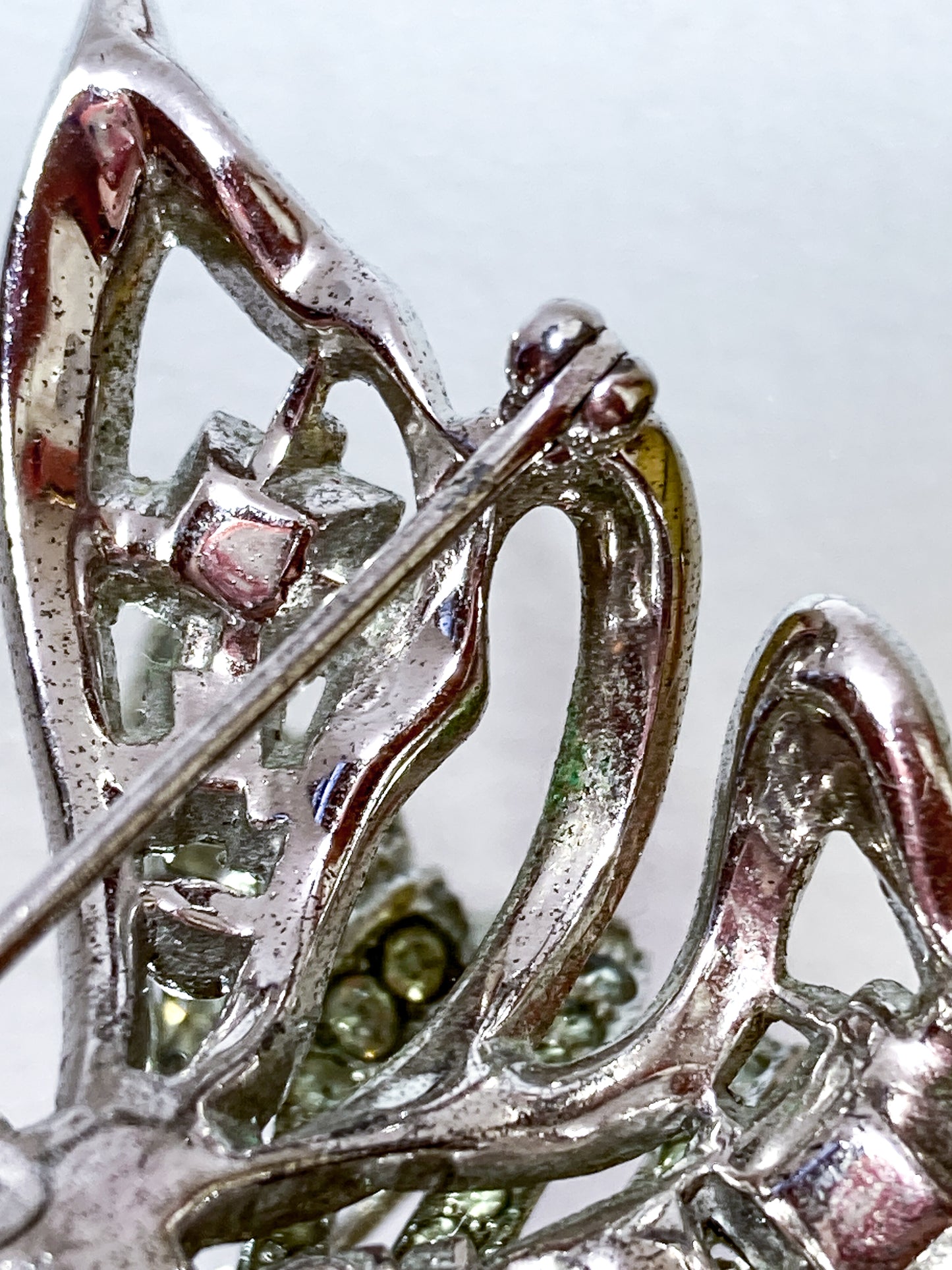 Vintage Coro Sterling Silver Clear Glass Rhinestone Asymmetric Bow Brooch Pin on mirrored white background close up
