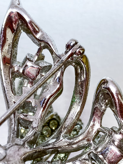 Vintage Coro Sterling Silver Clear Glass Rhinestone Asymmetric Bow Brooch Pin on mirrored white background close up