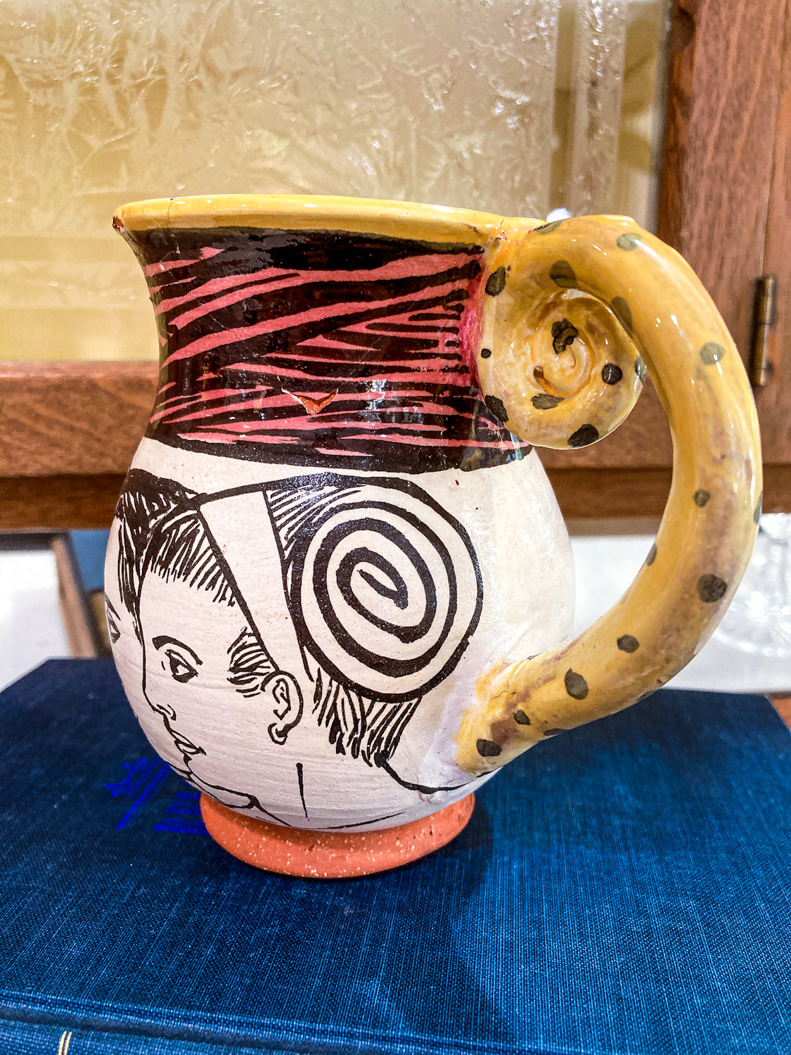 Ceramic pitcher with artistic design on a blue surface Vintage Daniel Postotnik Hand Potted Illustrative Portrait Mug As Found