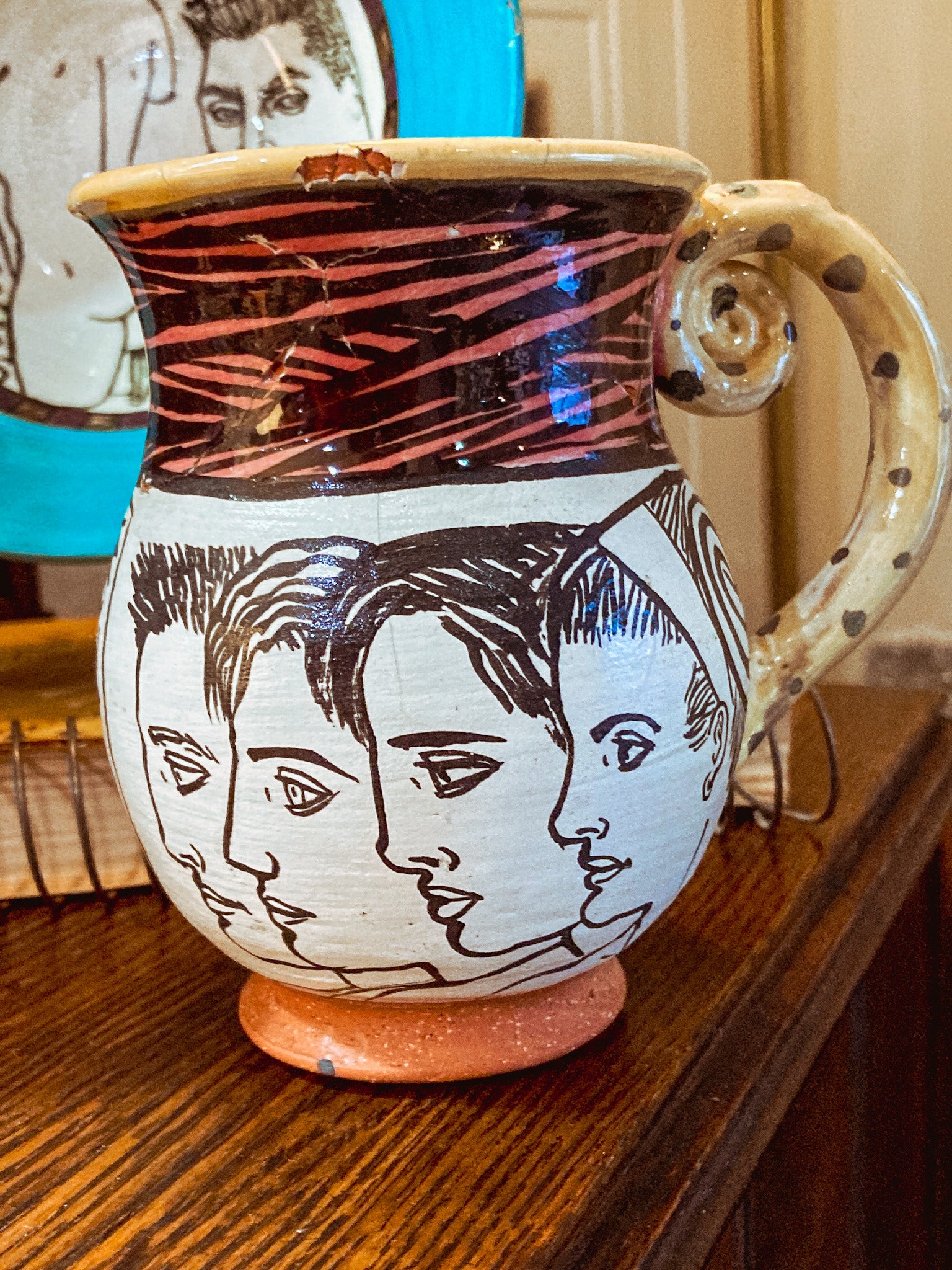 Ceramic mug with artistic faces on a wooden surface Vintage Daniel Postotnik Hand Potted Illustrative Portrait Mug As Found