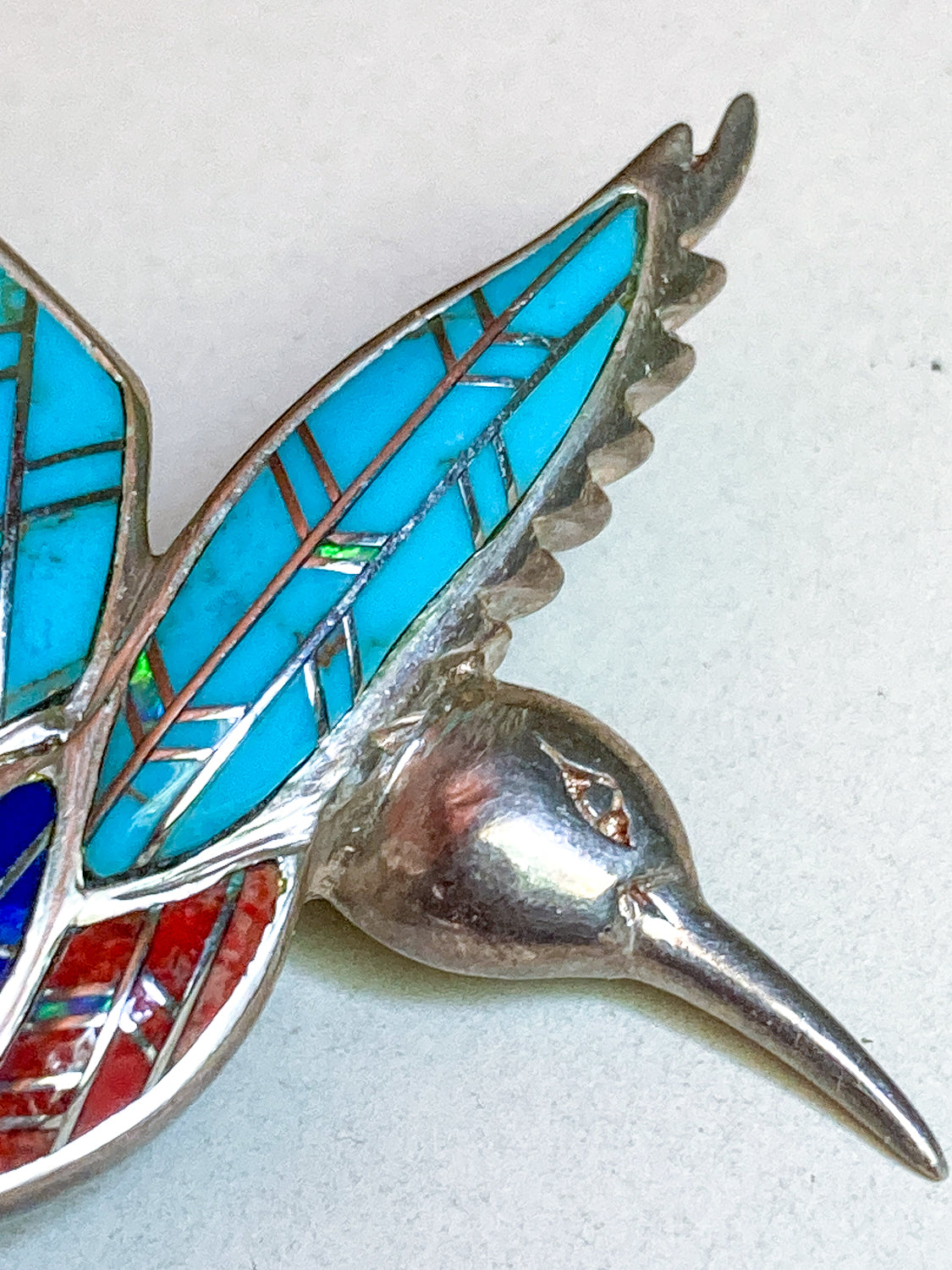 Vintage Sterling Silver Turquoise Gemstone Mosaic Inlay Hummingbird Brooch Silver hummingbird brooch with turquoise and red inlay on a light gray background