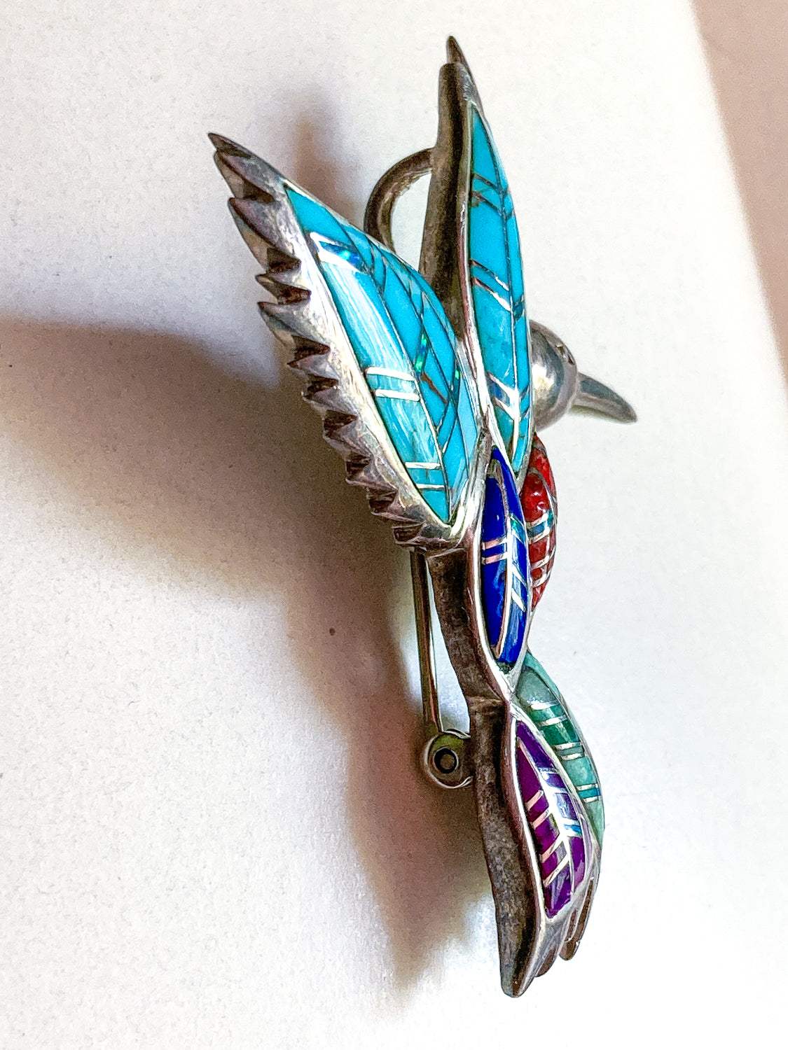 Multicolored Vintage Sterling Silver Turquoise Gemstone Mosaic Inlay Hummingbird Brooch with turquoise, red, and purple inlay on a white background